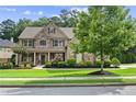 Beautifully landscaped two-story home with a stone facade and manicured front yard, perfect curb appeal at 134 Lakestone Pkwy, Woodstock, GA 30188