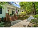 Inviting front porch with brick accents, American flag, and manicured landscaping at 4728 Corn Creek Drive, Fairburn, GA 30213