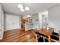 An open dining area features hardwood floors, a modern chandelier, and a view into the kitchen at 4413 Pinscher St, Union City, GA 30291