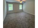 Spacious carpeted bedroom with a ceiling fan and windows offering natural light at 111 Deer Xing, Temple, GA 30179