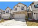 Inviting townhome with stone detailing, a two-car garage, neat landscaping, and an ADT security system at 5123 Tulip Sq, Acworth, GA 30101