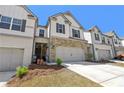 Lovely townhome with a two-car garage, featuring stone accents and a well-maintained front yard at 5123 Tulip Sq, Acworth, GA 30101