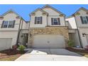 Attractive townhome featuring stone accents, gray trim, a two-car garage, and a welcoming front yard at 5123 Tulip Sq, Acworth, GA 30101