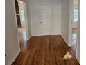 Hallway with hardwood floors leading to rooms with stone fireplace and natural light at 6419 Edenfield Dr, Lithonia, GA 30058