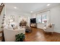 Sunlit living room with hardwood flooring, white sofa, and adjacent dining space at 2759 Arbor Se Ave, Atlanta, GA 30317