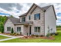 Elegant brick and siding home with manicured landscaping and a covered front entrance at 700 Relic Rdg, Hampton, GA 30228