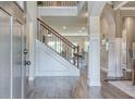 Elegant home foyer featuring wood floors, staircase with iron railing and white trim at 700 Relic Rdg, Hampton, GA 30228