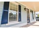 Stylish front porch featuring brick flooring, a classic dark front door, and elegant outdoor sconce lighting at 974 Regal Hills Ln, Mableton, GA 30126