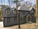 Gray home with prominent roof and dormers, complemented by a stone-accented entrance and mature trees at 270 Boulder Dr, Roswell, GA 30075