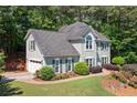Two-story home featuring a gray facade, attached garage, and colorful landscaped yard at 2009 Westside Ln, Woodstock, GA 30189