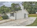 Rear view of brick home featuring an open, concrete patio and landscaped yard at 2714 Preston Dr, Decatur, GA 30034