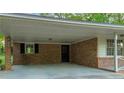 Attached brick carport with direct access to the house, providing sheltered parking at 2027 Kensington High Sw St, Lilburn, GA 30047