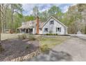 Charming two-story home with a long driveway and a detached garage nestled among mature trees at 1484 W Prospect Dr, Lawrenceville, GA 30043