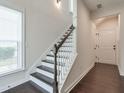 A modern staircase featuring dark wood floors, white risers and a white banister at 2032 Holtz Ln, Atlanta, GA 30318