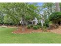Charming home with a well-manicured front lawn, mature trees, and inviting landscaping for a picturesque setting at 11165 Bentley Chase Dr, Johns Creek, GA 30097