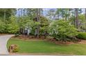 Beautiful home nestled among mature trees, showcasing a well-kept lawn and inviting curb appeal at 11165 Bentley Chase Dr, Johns Creek, GA 30097