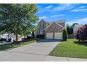 Inviting two-story home with a lush green lawn, mature trees, and a convenient two-car garage at 213 Roseman Way, Woodstock, GA 30188