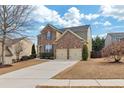 Two-story brick home with a two-car garage, complimented by a concrete driveway at 213 Roseman Way, Woodstock, GA 30188