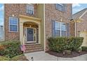 Welcoming front entrance with a stylish door, brick steps, and neatly trimmed greenery at 213 Roseman Way, Woodstock, GA 30188