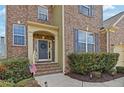Inviting front entrance with a wreath-adorned door, brick steps and manicured bushes at 213 Roseman Way, Woodstock, GA 30188