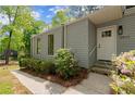 Front exterior featuring fresh landscaping, gray siding, a bright white door and stone steps at 3510 Holliglen Dr, Marietta, GA 30062