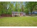 Well-maintained single-story brick home featuring a large grassy front yard at 2962 Invermere Woods Ct, Lithonia, GA 30038