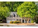 Charming brick home with lush landscaping, mature trees, and a cozy front porch at 4350 Oakdale Vinings Se Cir, Smyrna, GA 30080
