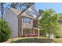 Well-maintained two-story house with a blend of stone and brick accents, surrounded by lush greenery and a neatly kept lawn at 4775 Columbia St, Cumming, GA 30040