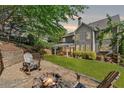 Spacious backyard with a fire pit, Adirondack chairs, and a covered patio for outdoor entertaining at 975 Garden Crossing Ln, Cumming, GA 30040