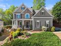 Beautiful two-story home with stone accents, a welcoming front porch, and lush landscaping in a desirable neighborhood at 975 Garden Crossing Ln, Cumming, GA 30040