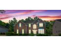 Red brick home at dusk with a colorful, cloud-filled sky at 1517 Granby Ln, Locust Grove, GA 30248