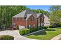 Beautiful red brick home with large driveway, green shutters, and mature trees at 1517 Granby Ln, Locust Grove, GA 30248