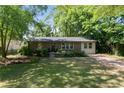 Quaint brick home with mature trees, green lawn and a long driveway at 3207 Canary Ct, Decatur, GA 30032