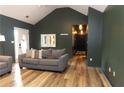 Living room view featuring modern gray couches, wood floors, and dark green walls at 1043 Foxhollow Trl, Canton, GA 30115