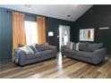Bright living room featuring wood floors, modern gray couches, neutral decor, and a large window at 1043 Foxhollow Trl, Canton, GA 30115