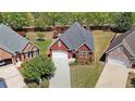 High-angle view showcasing a red brick house, green lawn, and paved driveway in a well-kept neighborhood at 1610 Glenhurst Dr, Snellville, GA 30078