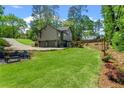Serene backyard featuring a lush lawn, mature trees, and charming string lights for outdoor gatherings at 3603 Allpoint Dr, Marietta, GA 30062