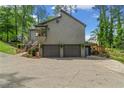 Side view of the home with two-car garage, a cantilevered sunroom and a lush lawn at 3603 Allpoint Dr, Marietta, GA 30062