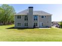 Back exterior of a two-story home featuring a large backyard with plenty of green space at 100 Wyngate Chase, Stockbridge, GA 30281