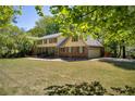 Traditional home with brick accents, complemented by a well-maintained lawn and mature trees at 1851 Mount Vernon Rd, Dunwoody, GA 30338