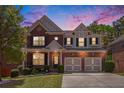Beautiful two-story brick home featuring a two-car garage, manicured lawn, and lovely landscaping at 5011 Weathervane Dr, Alpharetta, GA 30022