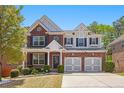 Charming two-story home with brick and siding, a two-car garage, and well-maintained front yard at 5011 Weathervane Dr, Alpharetta, GA 30022