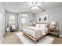 Cozy bedroom with a ceiling fan, modern decor, and natural light from the nearby windows and exterior door at 4201 Stratford Commons, Decatur, GA 30033