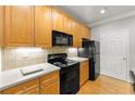 Close up of kitchen featuring light wood cabinetry and modern black appliances at 4201 Stratford Commons, Decatur, GA 30033