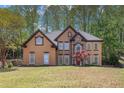 Charming two-story home with a well-maintained lawn and mature trees in background at 4609 Mctyre Way, Marietta, GA 30064