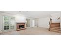 Bright living room featuring a brick fireplace, large windows, and a staircase at 595 Saint James Se Walk, Marietta, GA 30067