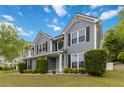 Attractive gray home with white trim, lush landscaping, and a well-kept lawn, creating a warm, inviting entrance at 900 Hillary Ln, Lawrenceville, GA 30043