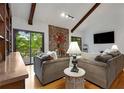 Cozy living room features hardwood floors, vaulted ceilings with wood beams, and a striking stone fireplace at 9295 Martin Rd, Roswell, GA 30076