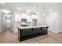 Modern kitchen with black island, white cabinets, stainless steel appliances, and pendant lighting at 166 Bluffington Way, Marietta, GA 30066