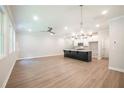 Bright, open-concept living room with wood floors and stylish light fixtures adjoining modern kitchen at 166 Bluffington Way, Marietta, GA 30066